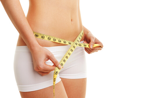 Woman measuring her bare waist